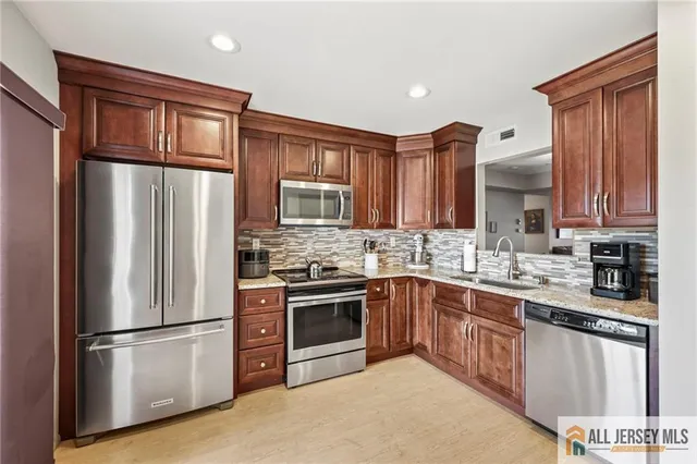 a kitchen with stainless steel appliances granite countertop a refrigerator stove microwave and sink