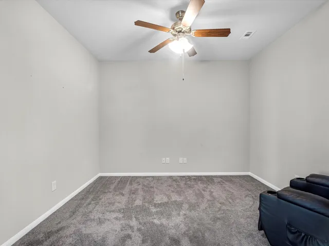 a view of an empty room with a ceiling fan