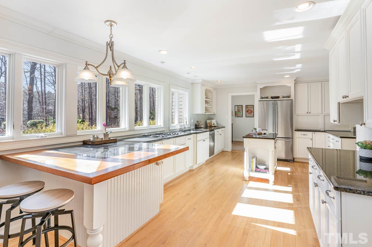 113 Bruce Drive Cary, NC 27511 - Photo 18 of 48 a large kitchen with kitchen island a large counter top space a sink stainless steel appliances and cabinets