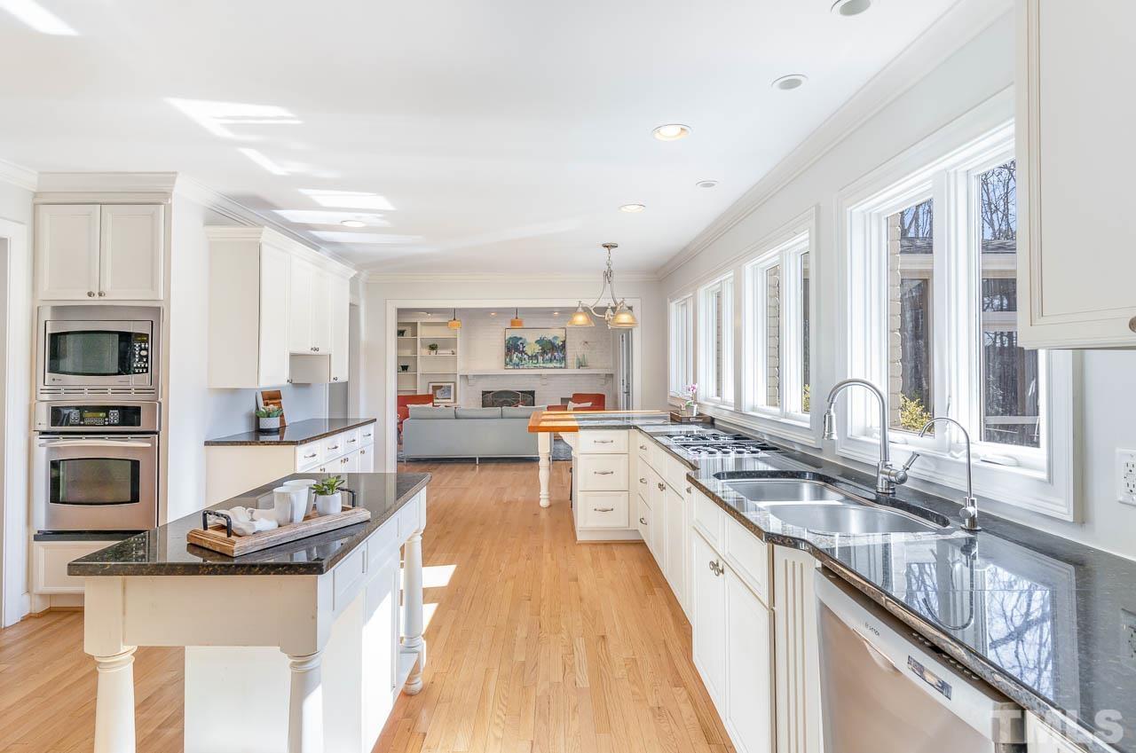 113 Bruce Drive Cary, NC 27511 - Photo 25 of 48 a large white kitchen with stainless steel appliances granite countertop a stove and a sink