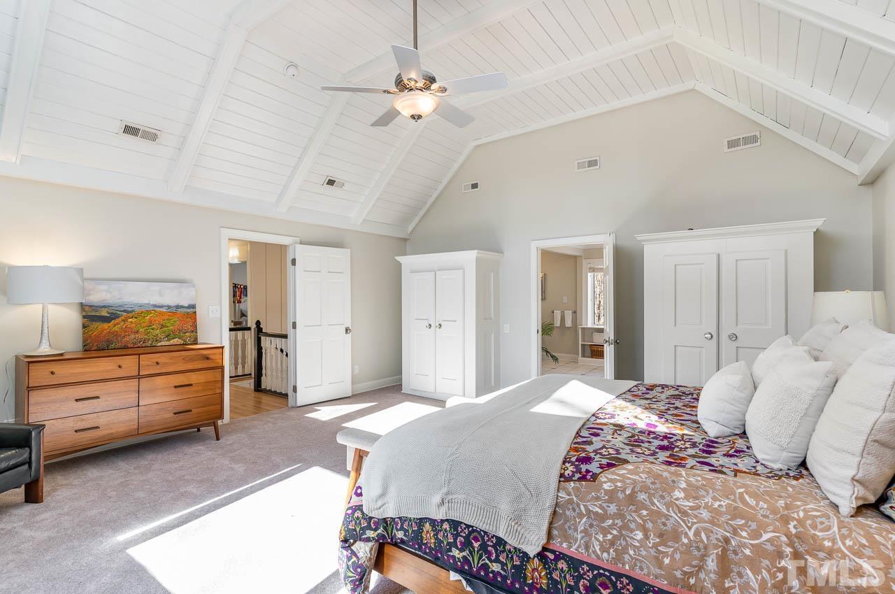 113 Bruce Drive Cary, NC 27511 - Photo 32 of 48 a bedroom with a large bed and a chandelier