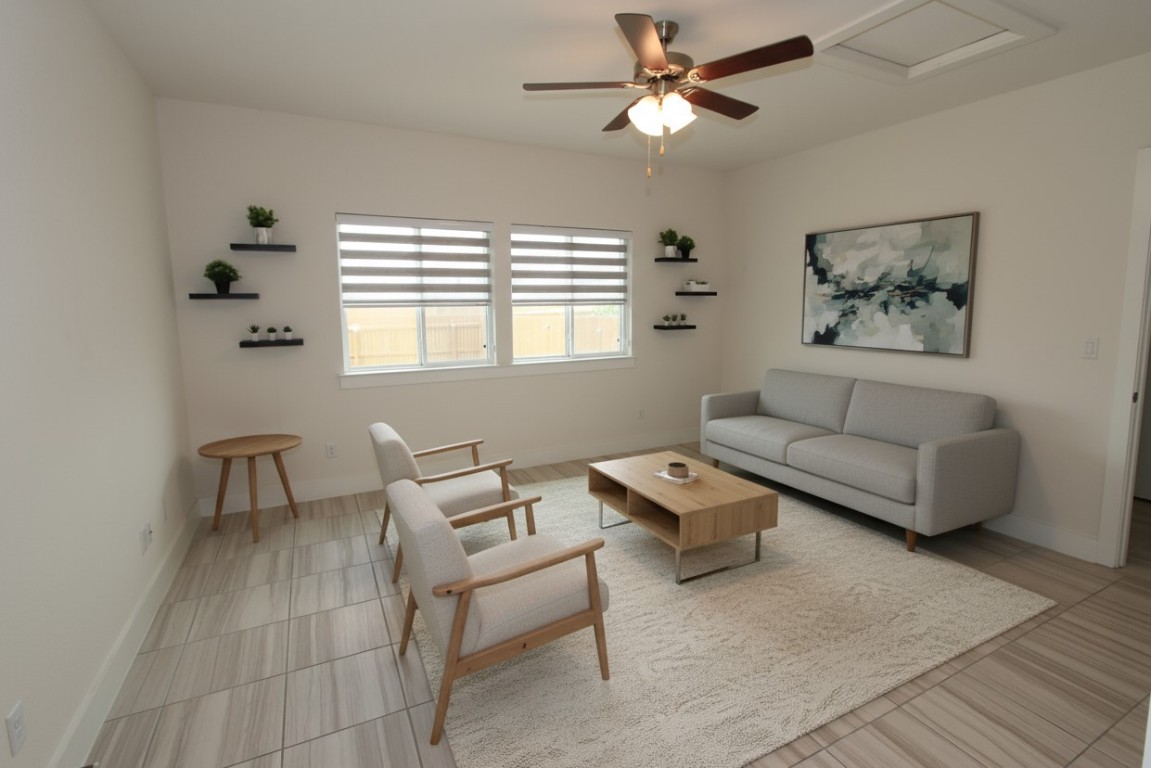 Living room with a ceiling fan and baseboards (photos may reflect virtual staging of furniture)