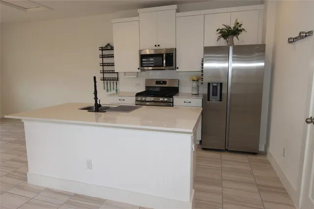 a kitchen with a sink a stove and a refrigerator