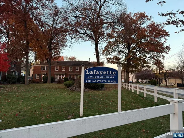 a view of a street sign under a large tree