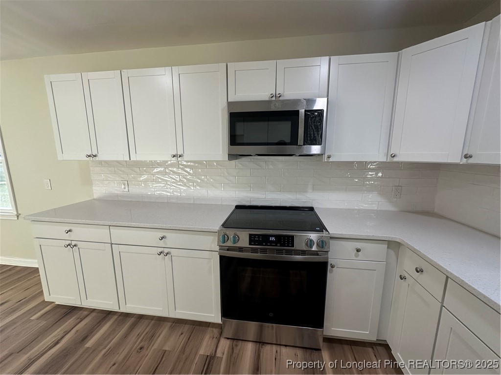 411 Lafayette Street Clinton, NC 28328 - Photo 12 of 24 a kitchen with white cabinets and black appliances