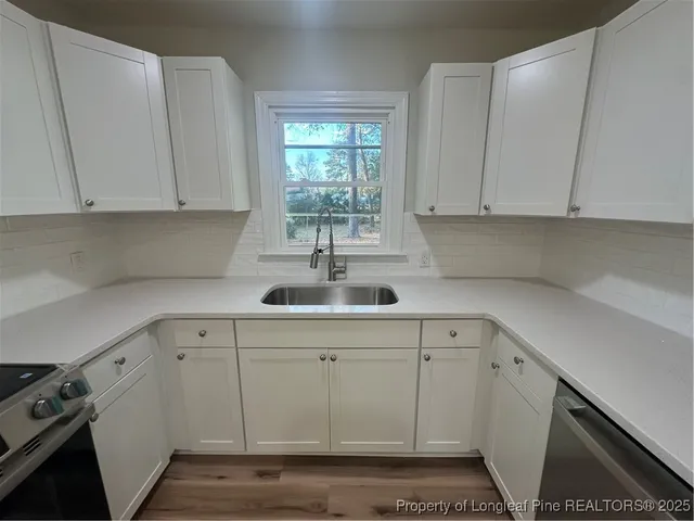 a kitchen with white cabinets and white appliances