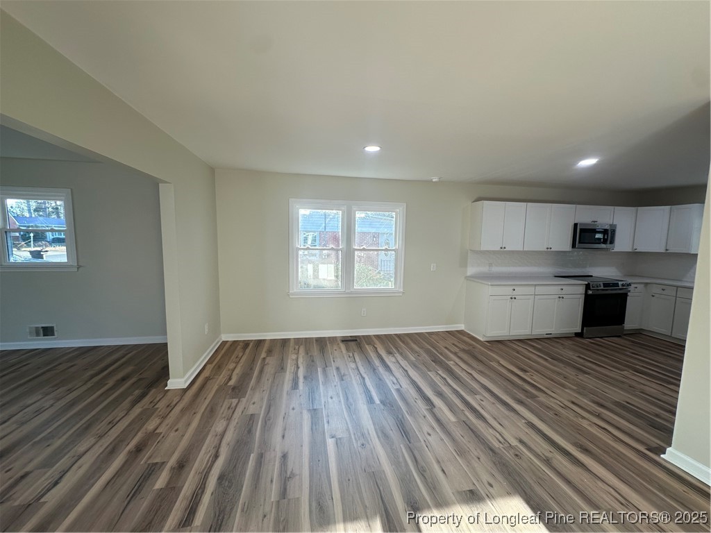 411 Lafayette Street Clinton, NC 28328 - Photo 15 of 24 an empty room with wooden floor kitchen view and a window