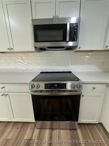 a stove top oven sitting inside of a kitchen