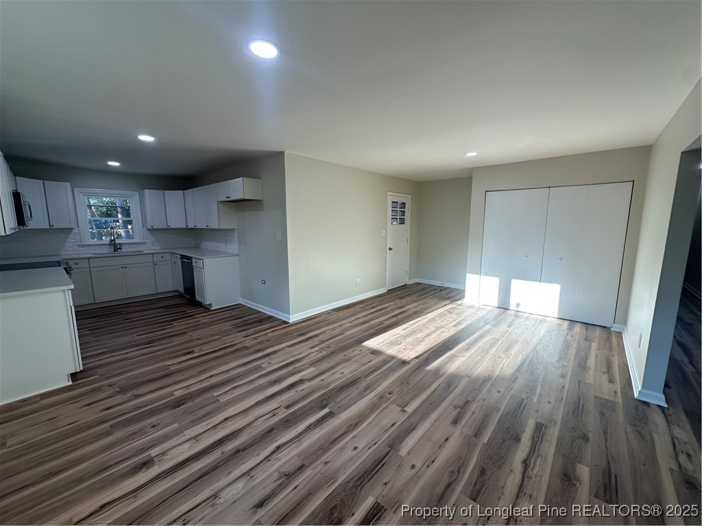 411 Lafayette Street Clinton, NC 28328 - Photo 10 of 24 a open kitchen with kitchen island white cabinets and wooden floor