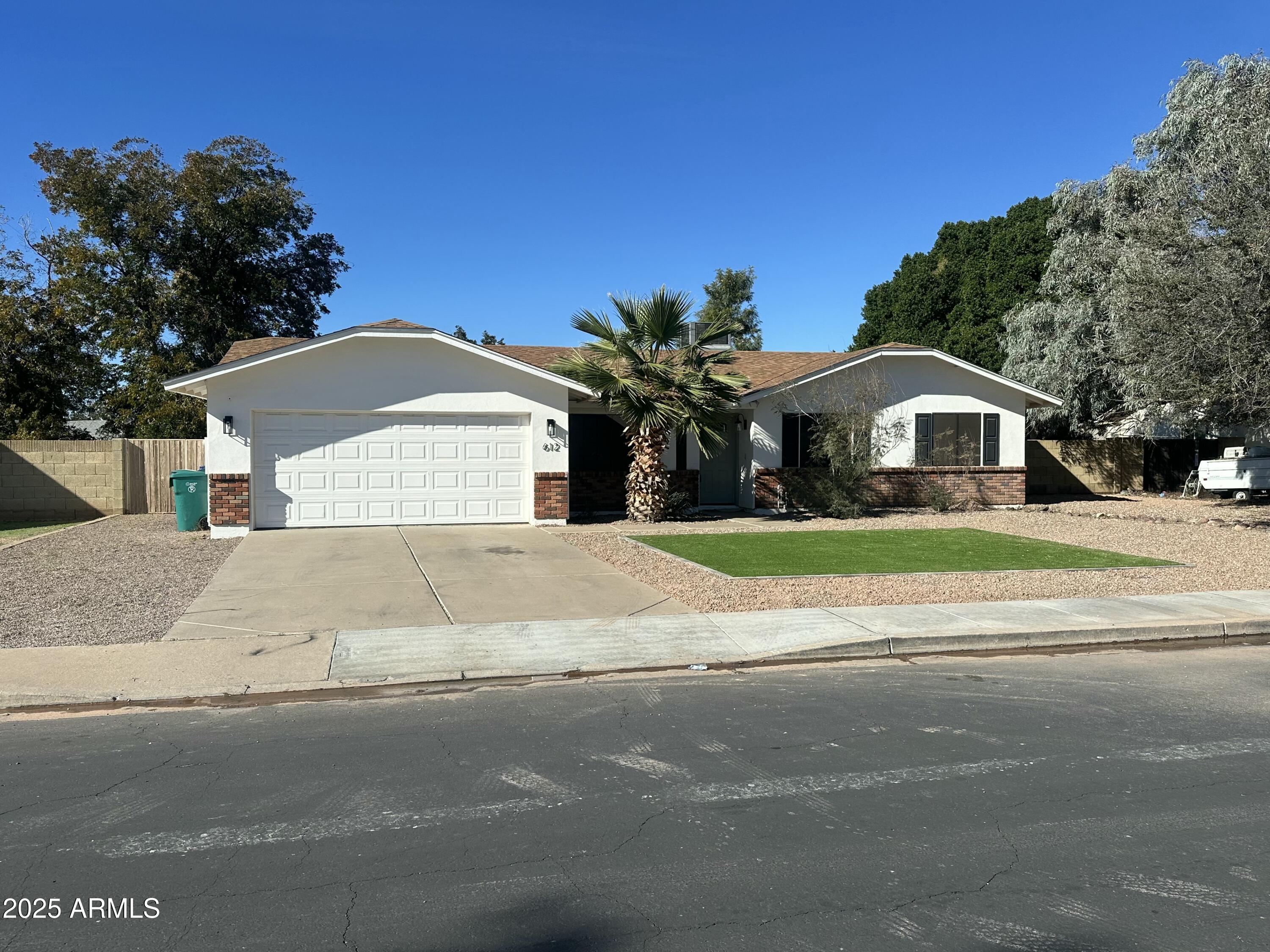Undisclosed Address Mesa, AZ 85213 - Photo 1 of 10 a front view of a house with a garden and trees