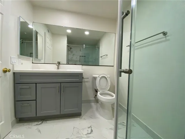 a bathroom with a sink a toilet a shower and a mirror