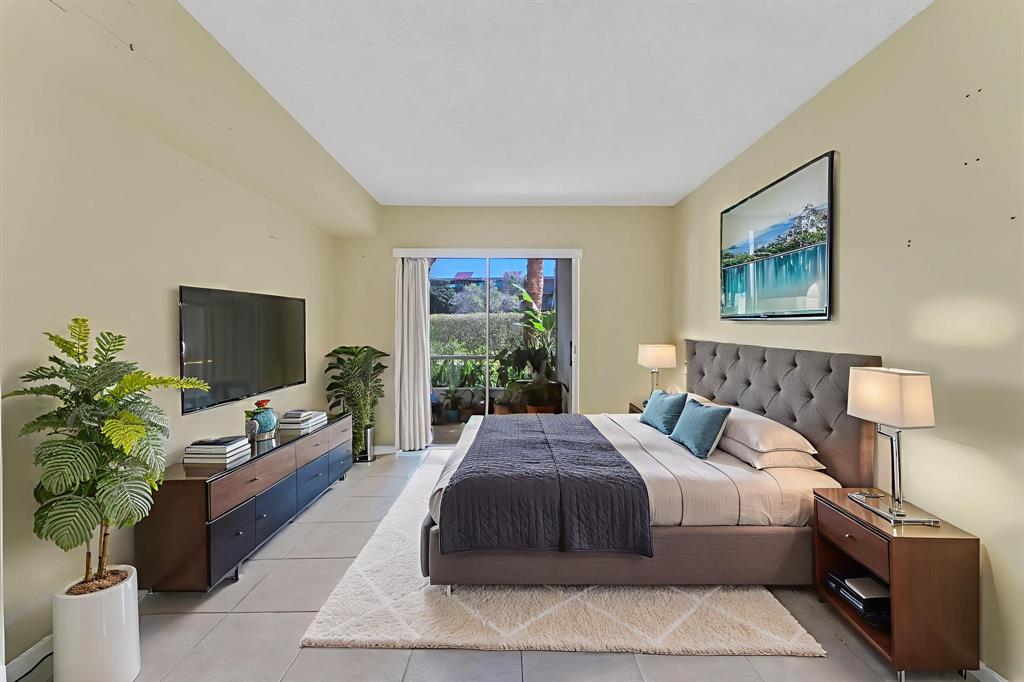 331 Northwest 76th Avenue, Unit 104 Margate, FL 33063 - Photo 13 of 30 a bedroom with a large bed and a flat screen tv