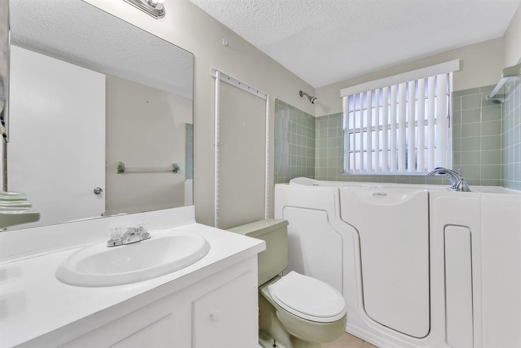 331 Northwest 76th Avenue, Unit 104 Margate, FL 33063 - Photo 15 of 30 a bathroom with a sink a toilet and a mirror