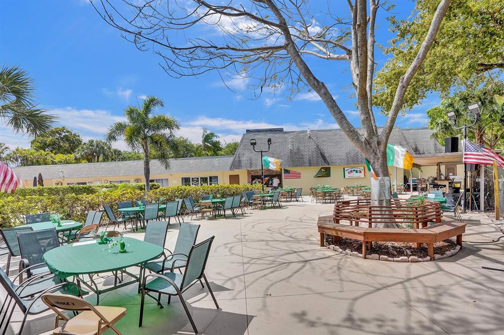 331 Northwest 76th Avenue, Unit 104 Margate, FL 33063 - Photo 29 of 30 a view of a patio with a table and chairs under an umbrella