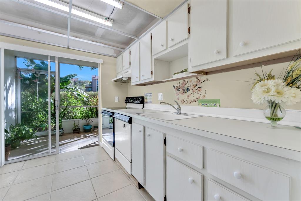 331 Northwest 76th Avenue, Unit 104 Margate, FL 33063 - Photo 4 of 30 a kitchen with stainless steel appliances white cabinets and a potted plant