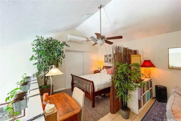a bedroom with a bed table and a potted plant
