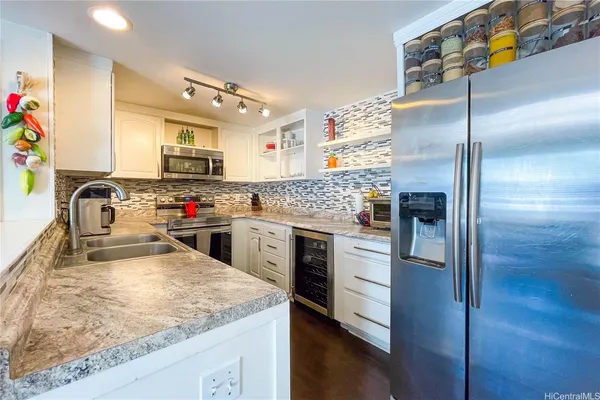 a kitchen with kitchen island granite countertop a sink appliances and cabinets