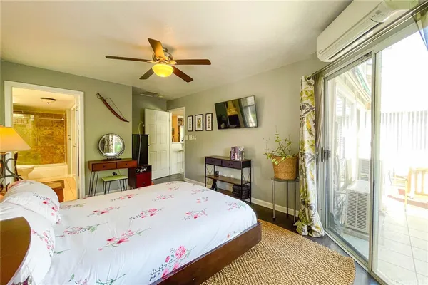 a bed room with a bed a flat tv screen and a dresser