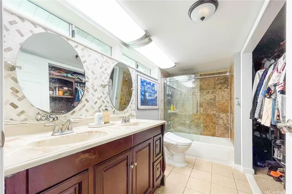 a bathroom with a double vanity sink toilet mirror and shower