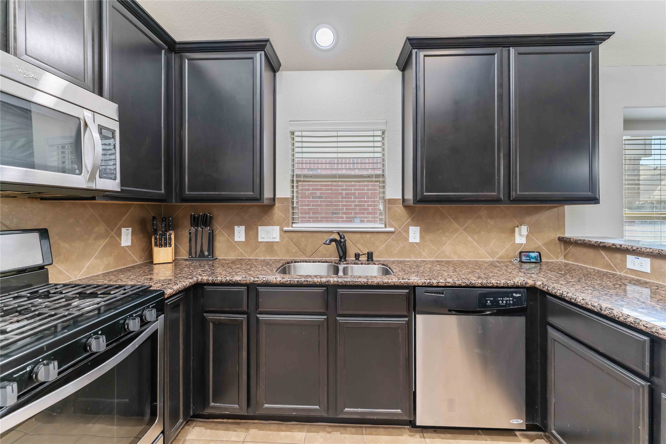 8226 Silent Deep Drive Rosenberg, TX 77469 - Photo 4 of 23 a kitchen with granite countertop a sink stove and cabinets