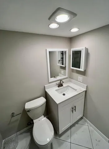 a bathroom with a toilet sink and mirror