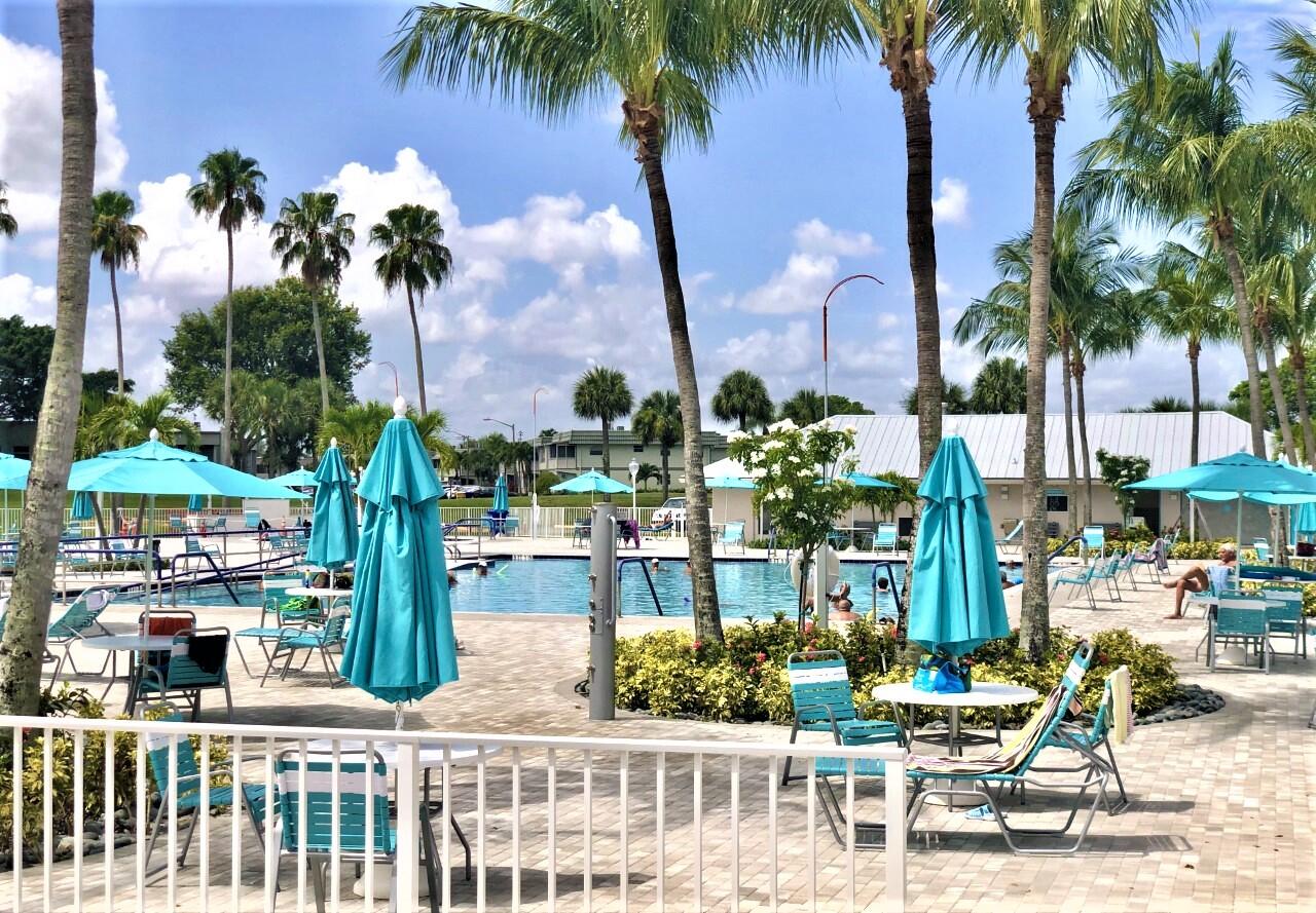 20 Saxony A, Unit A Delray Beach, FL 33446 - Photo 30 of 50 a front view of multi story residential apartment building with yard and outdoor seating