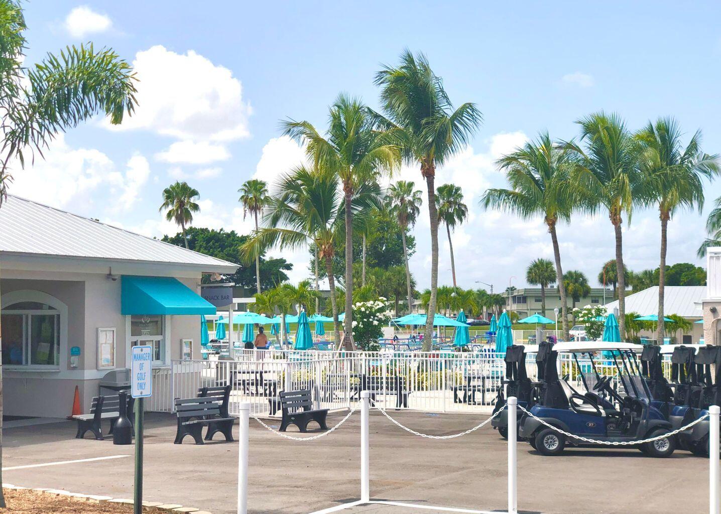 20 Saxony A, Unit A Delray Beach, FL 33446 - Photo 39 of 50 a patio with a table and chairs and potted plants
