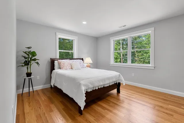 a large bed sitting in a bedroom next to a window