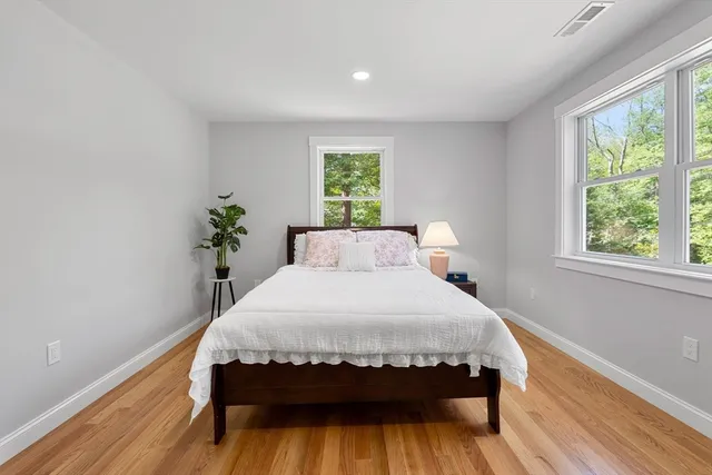 a bedroom with a bed and wooden floor