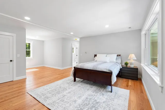 a spacious bedroom with a bed and wooden floor