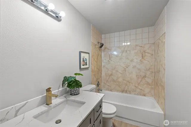 a bathroom with a sink a toilet and shower