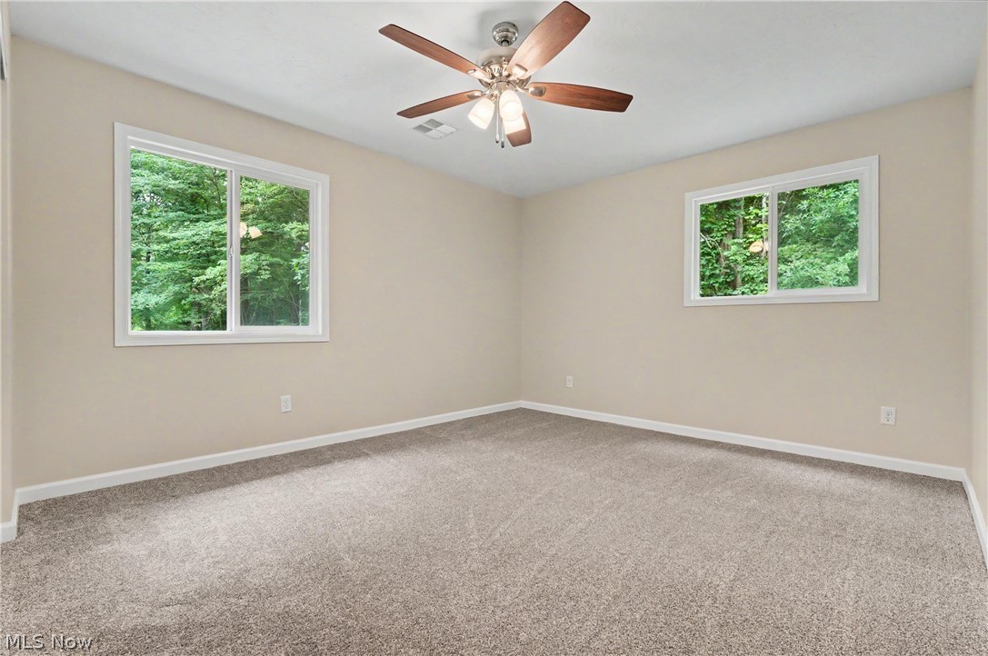 7583 Yale Road Atwater, OH 44201 - Photo 28 of 41 Bedroom two with brand new 2026: paint, carpet, ceiling fan, windows, man door, and closet door.