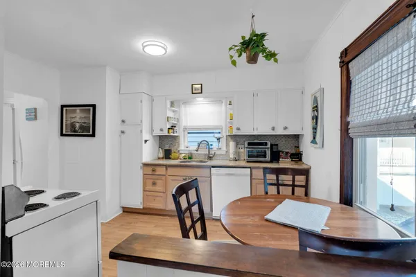 a kitchen with kitchen island a stove a sink a dining table and chairs