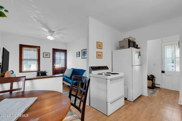 a living room with furniture a dining table and a refrigerator
