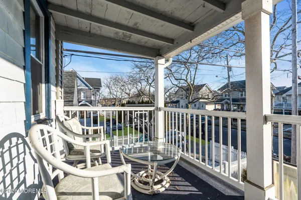 a view of a balcony with wooden chairs