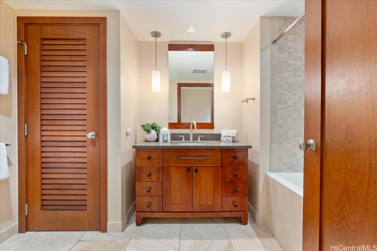 92-104 Waialii Place, Unit O422 Kapolei, HI 96707 - Photo 13 of 25 a bathroom with a sink a vanity and a mirror