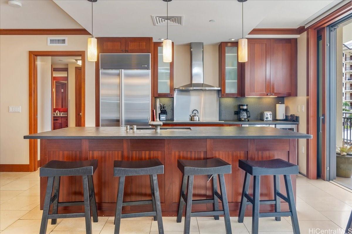 92-104 Waialii Place, Unit O422 Kapolei, HI 96707 - Photo 4 of 25 a kitchen with a table chairs refrigerator and cabinets