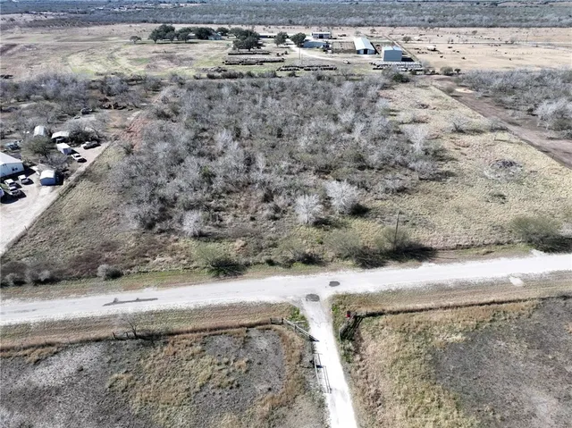 a view of a dry yard with wooden fence