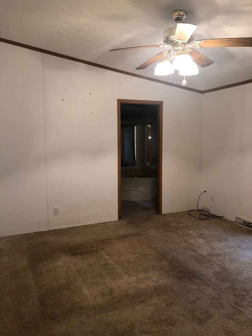 1043 Brewster Road Amboy, IL 61310 - Photo 3 of 17 an empty room with a chandelier fan and windows