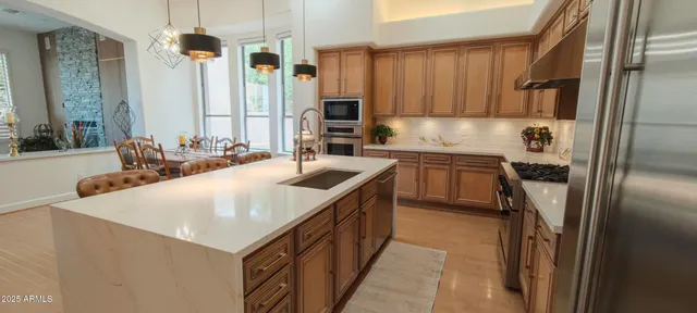 a kitchen with stainless steel appliances a refrigerator a stove a sink and a refrigerator