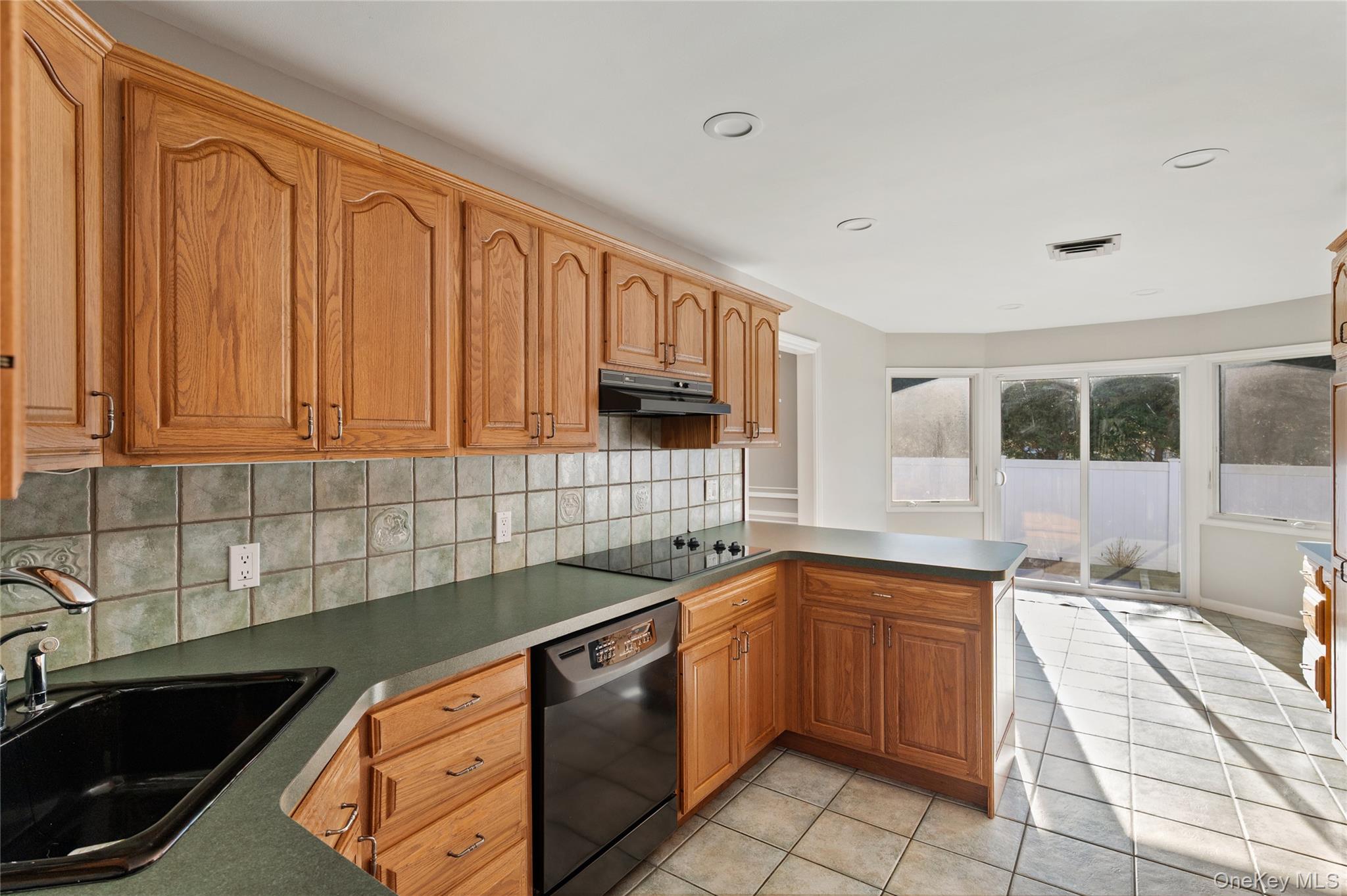 148 Exeter Road Massapequa, NY 11758 - Photo 13 of 28 a kitchen with a sink stove and cabinets