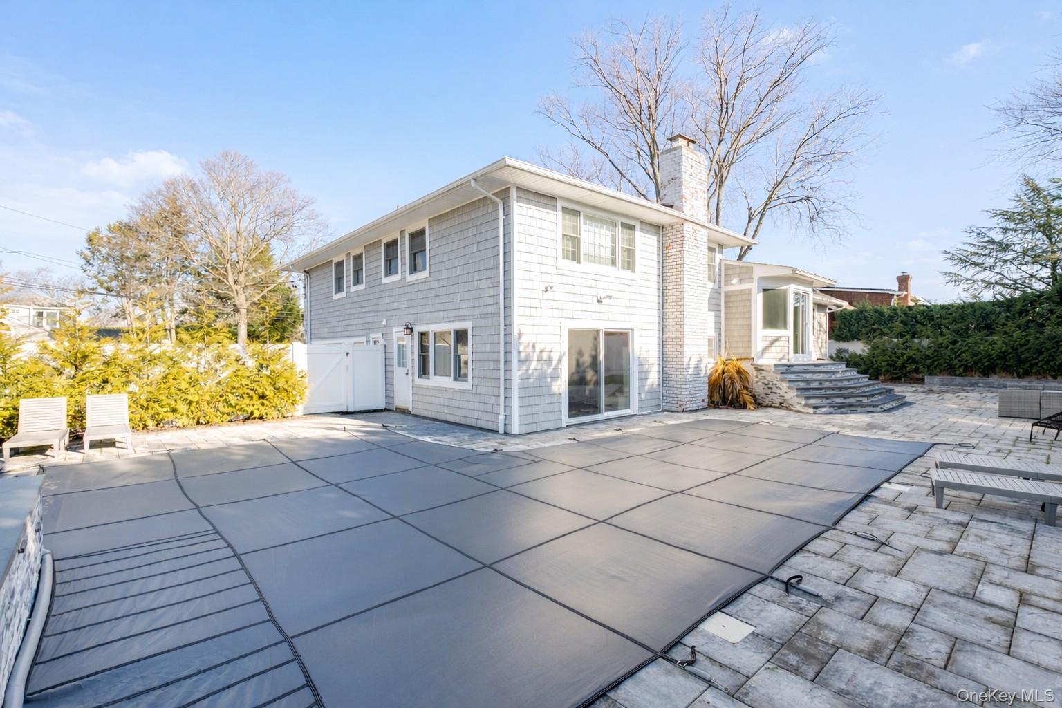 148 Exeter Road Massapequa, NY 11758 - Photo 26 of 28 a view of a white house with a yard and potted plants