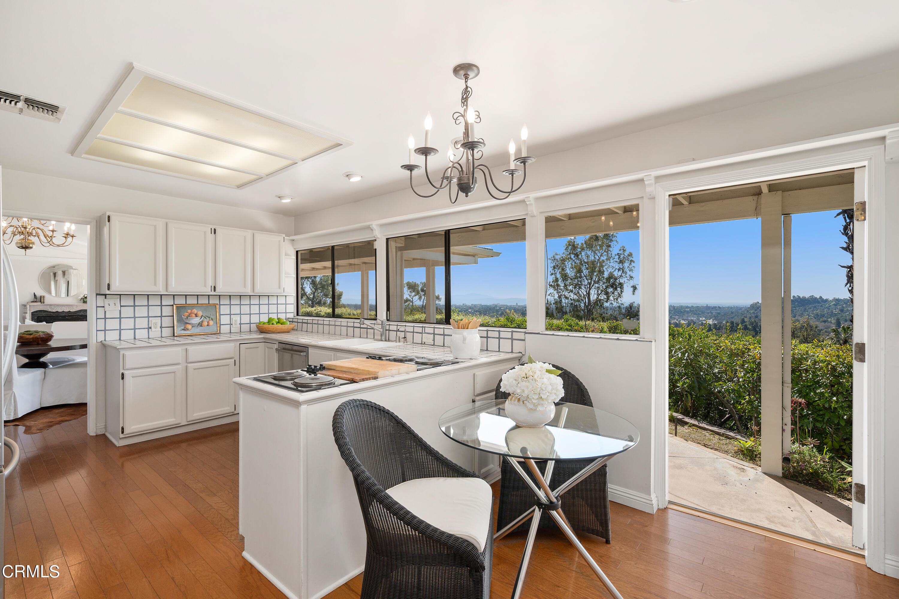 1444 Normandy Drive Pasadena, CA 91103 - Photo 7 of 25 a dining room with wooden floor a chandelier a wooden table and chairs