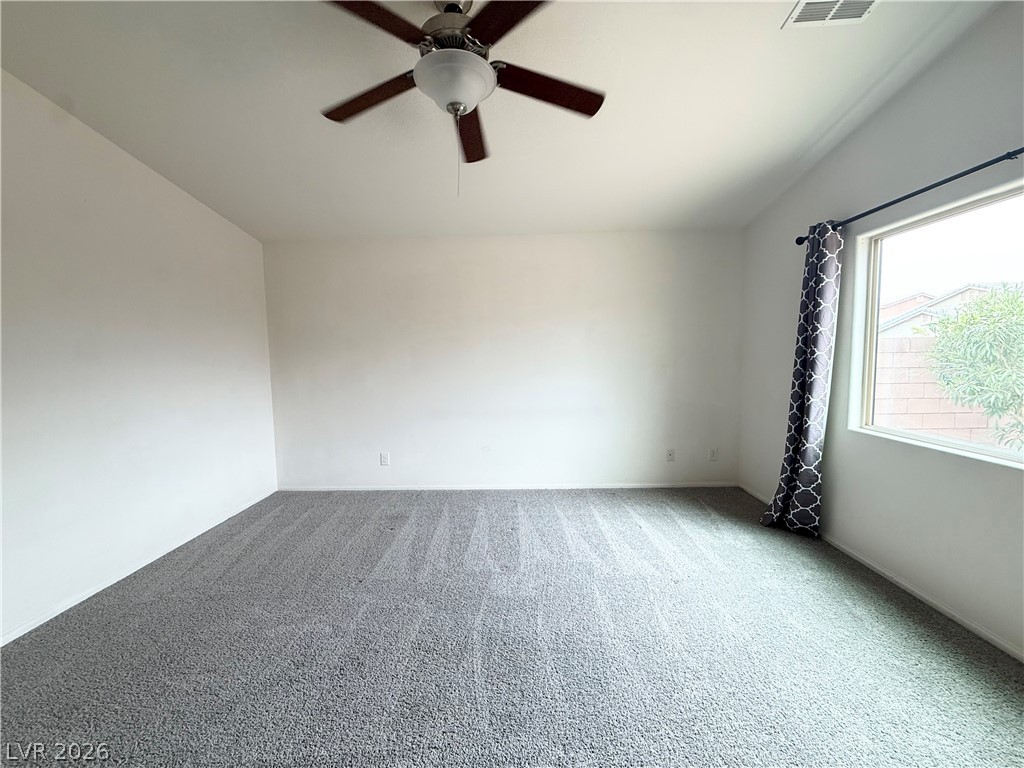 8231 Buffalo Ranch Avenue Las Vegas, NV 89147 - Photo 11 of 22 A well-lit bedroom features plush carpeting and a convenient ceiling fan.
