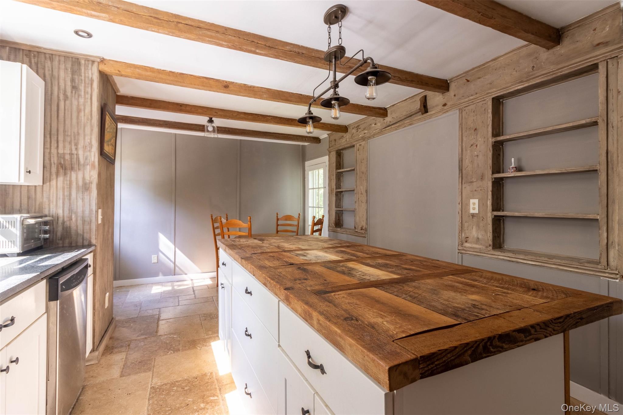 19450 Main Road Mattituck, NY 11952 - Photo 5 of 16 Kitchen featuring white cabinetry, wooden counters, stone tile floors, pendant lighting, and dishwasher