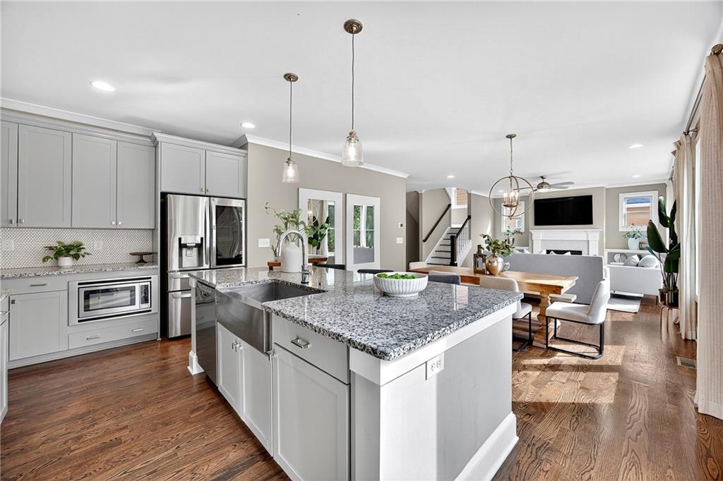 2675 Sugar Mill Drive Southeast Atlanta, GA 30316 - Photo 12 of 38 a kitchen with stainless steel appliances kitchen island granite countertop a stove top oven a sink dishwasher a dining table and chairs with wooden floor