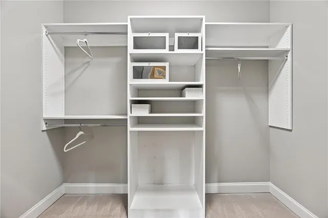 a view of walk in closet with empty racks
