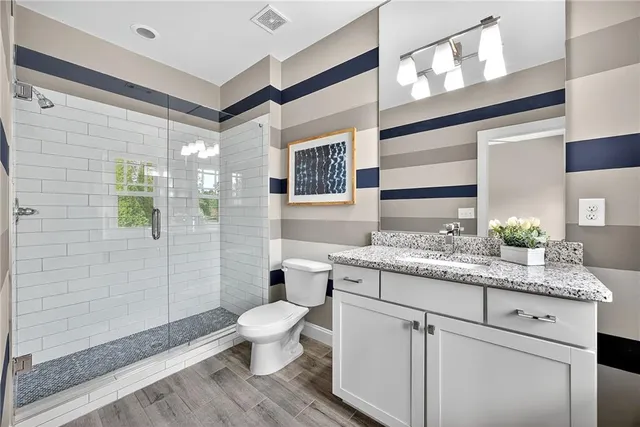 a bathroom with a granite countertop sink toilet and shower