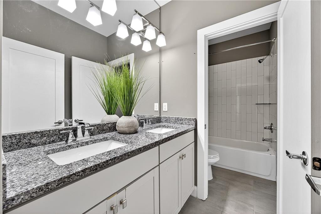 2675 Sugar Mill Drive Southeast Atlanta, GA 30316 - Photo 24 of 38 a bathroom with a granite countertop sink a mirror and a bathtub
