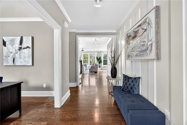 a hallway with wooden floor and windows